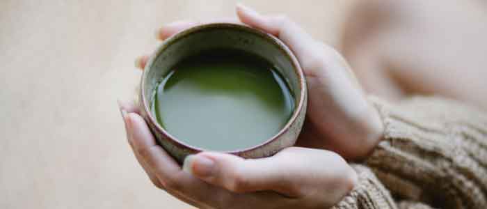 holding a bowl of brewed matcha