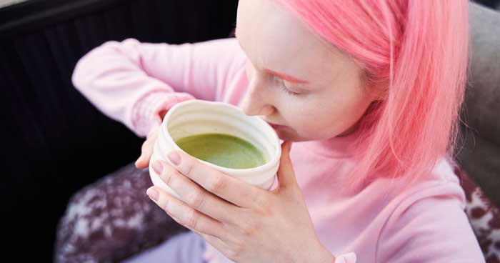 woman drinking matcha tea from a matcha bowl