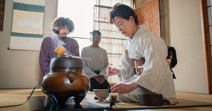 a japanese tea host preparing matcha for her guests