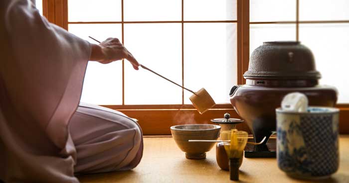 a person preparing japanese tea ceremony using traditional japanese tea ceremony tools and utensils